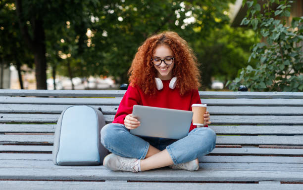 istock Happy female student enjoying coffee and using laptop 1223714383