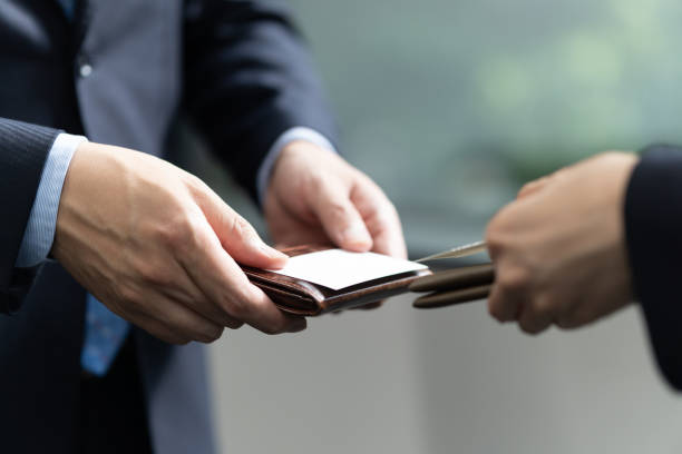 A close-up of a Japanese businessman exchanging business cards A close-up of a Japanese businessman exchanging business cards business card photos stock pictures, royalty-free photos & images