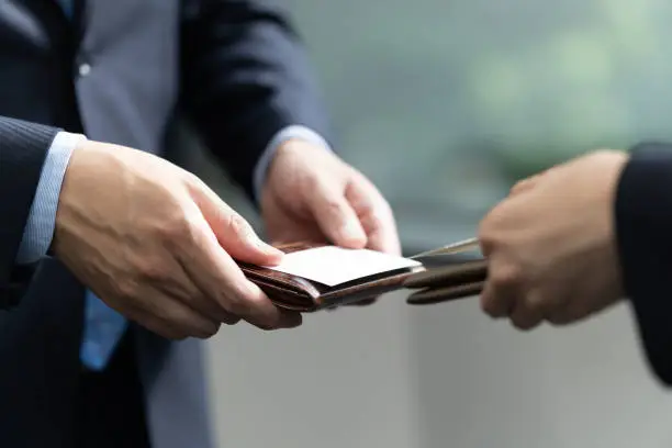 A close-up of a Japanese businessman exchanging business cards