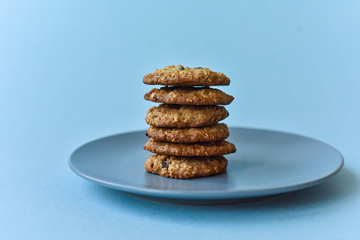 A group of baked oatmeal raisin cookies on a parchment sheet