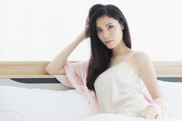 istock Asian woman model sitting and posing on bed. 1223729292