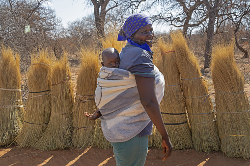African mother carry child in the back in a rural area in her village in Botswana