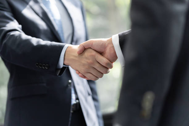 empresários japoneses apertam as mãos uns aos outros - business handshake meeting human hand - fotografias e filmes do acervo