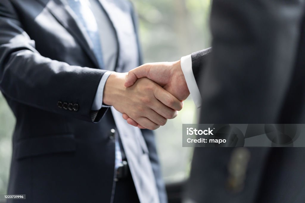 Японские бизнесмены-мужчины пожимают друг другу руки - Стоковые фото Рукопожатие роялти-фри