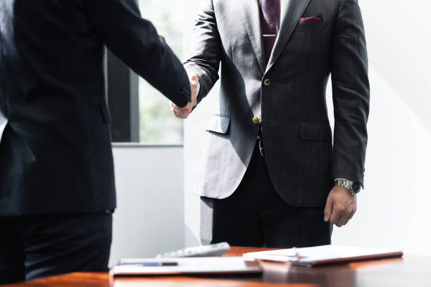 Japanese male businessmen shake hands with each other Japanese male businessmen shake hands with each other talking two people business talk business stock pictures, royalty-free photos & images