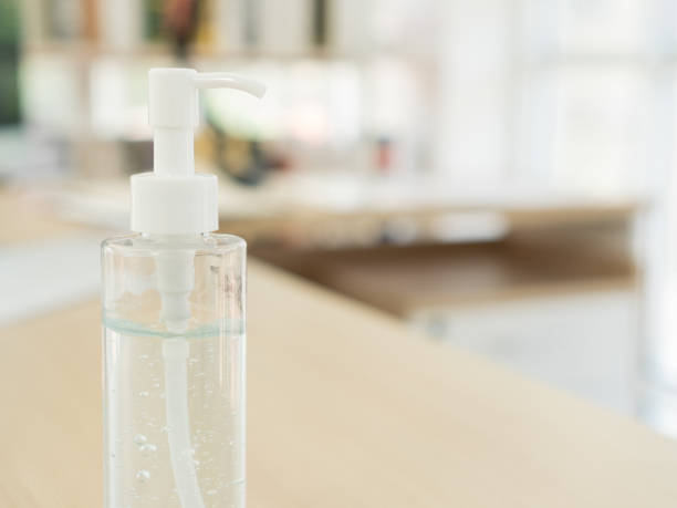 An alcohol gel bottle is on the desk in the home office. stock photo