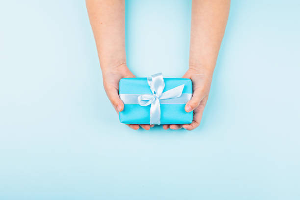 istock Happy Fathers Day background. Kid holding hands blue gift box on table. Flat lay style, top view, overhead, mockup, template, copy space 1223732962