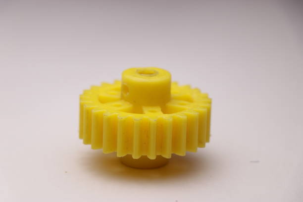 istock Plastic gear which is yellow in color and having teeth used in making projects attached to dc gear motors 1223734814