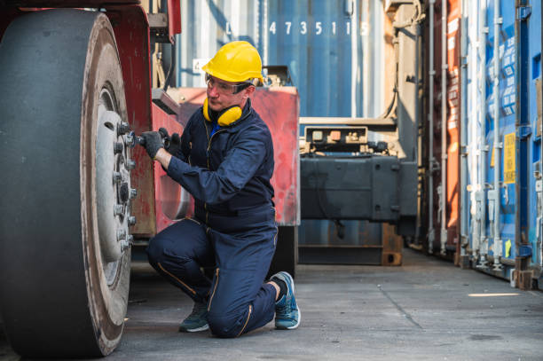 istock Worker man operate checking and fix the wheels forklift crane at container cargo harbor. 1223738248