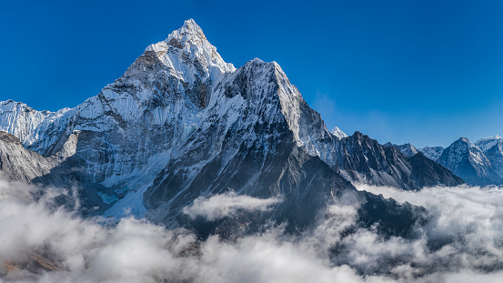 59 MPix XXXXL size panorama of Mount Ama Dablam - probably the most beautiful peak in Himalayas. \n This panoramic landscape is an very high resolution multi-frame composite and is suitable for large scale printing\nAma Dablam is a mountain in the Himalaya range of eastern Nepal. The main peak is 6,812  metres, the lower western peak is 5,563 metres. Ama Dablam means  'Mother's neclace'; the long ridges on each side like the arms of a mother (ama) protecting  her child, and the hanging glacier thought of as the dablam, the traditional double-pendant  containing pictures of the gods, worn by Sherpa women. For several days, Ama Dablam dominates  the eastern sky for anyone trekking to Mount Everest basecamp