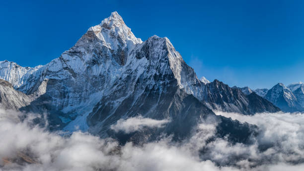 Panoramic 59 MPix XXXXL size view of Mount Ama Dablam in Himalayas, Nepal 59 MPix XXXXL size panorama of Mount Ama Dablam - probably the most beautiful peak in Himalayas. 
 This panoramic landscape is an very high resolution multi-frame composite and is suitable for large scale printing
Ama Dablam is a mountain in the Himalaya range of eastern Nepal. The main peak is 6,812  metres, the lower western peak is 5,563 metres. Ama Dablam means  'Mother's neclace'; the long ridges on each side like the arms of a mother (ama) protecting  her child, and the hanging glacier thought of as the dablam, the traditional double-pendant  containing pictures of the gods, worn by Sherpa women. For several days, Ama Dablam dominates  the eastern sky for anyone trekking to Mount Everest basecamp himalayas photos stock pictures, royalty-free photos & images