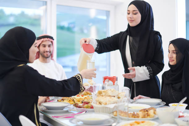 istock Muslim family having Iftar dinner drinking water to break feast 1223739182