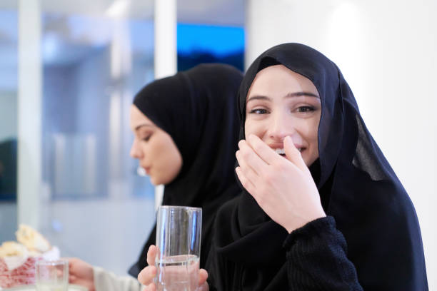 istock Muslim family having Iftar dinner drinking water to break feast 1223739199