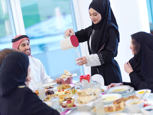 istock Muslim family having Iftar dinner drinking water to break feast 1223739204