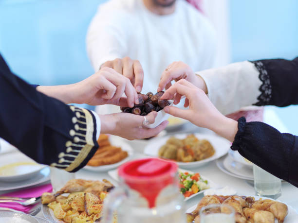 istock Muslim family having Iftar dinner eating dates to break feast 1223739206