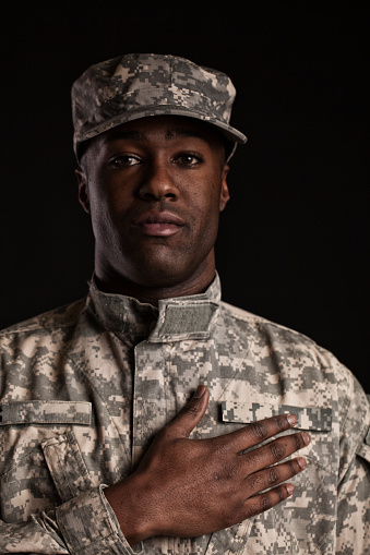 black soldier in uniform with hand on heart