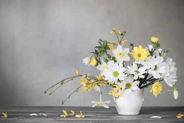 istock spring white and yellow flowers on background old wall 1223744477