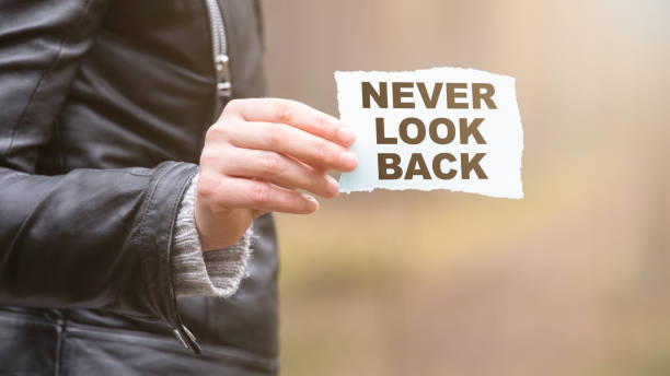 istock NEVER LOOK BACK concept. Text on the sheet in hand 1223745079