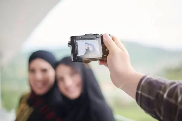 Photo of a man takes a photo of muslim women with a camera