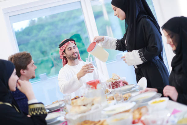 istock Muslim family having Iftar dinner drinking water to break feast 1223745297