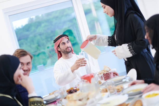 istock Muslim family having Iftar dinner drinking water to break feast 1223745298