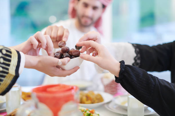 istock Muslim family having Iftar dinner eating dates to break feast 1223745305