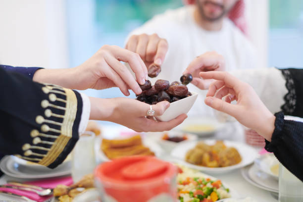 istock Muslim family having Iftar dinner eating dates to break feast 1223745309