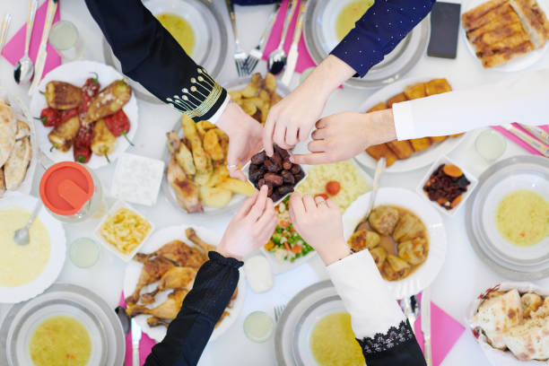 istock Muslim family having Iftar dinner eating dates to break feast top view 1223745311