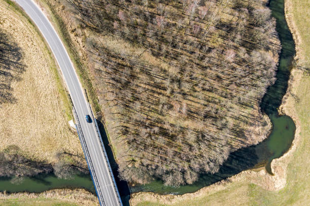 istock spring sunny rural landscape with road, bridge, river, fields and forest. aerial top view 1223749883