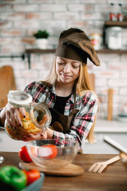 istock Beautiful young girl having fun while preparing the food. 1223752233