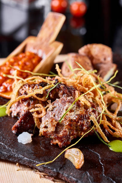 istock Grilled Beef steak Ribeye with roasted potato on cutting board. With deep-fried onions and tomato sauce. 1223752305