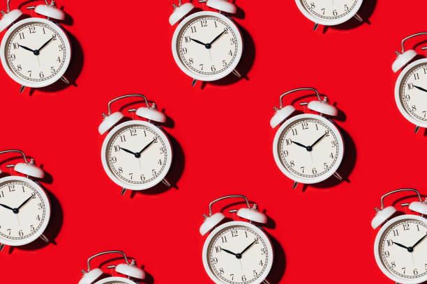 istock Pattern of white alarm clock on red background. Wake up alert concept. Morning routine. Back to school concept. Minimalist style design. Packing design. Creative design, minimal flat lay concept 1223753001