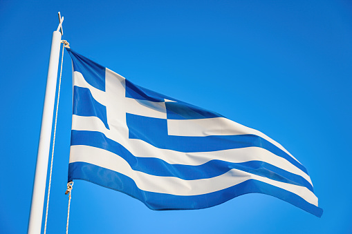 Greek Flag against sunny clear blue sky blowing in the Wind.  Crete Island, Greece, Mediterranean Countries, Europe