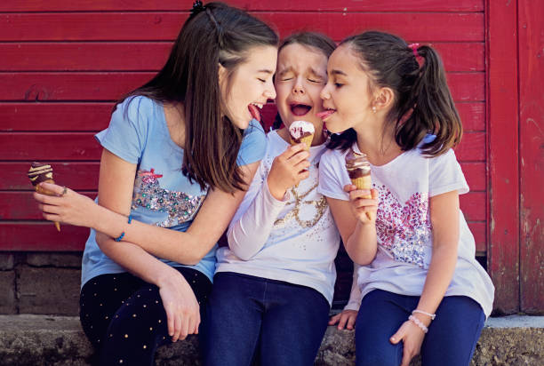 Girlfriends are eating ice cream and having fun together Girlfriends are eating ice cream and having fun together stealing ice cream stock pictures, royalty-free photos & images
