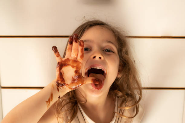 istock Little girl with chocolate stained hands 1223756125
