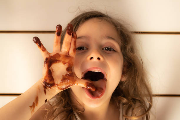 istock Little girl with chocolate stained hands 1223756126