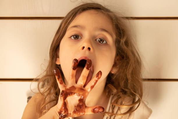 istock Little girl with chocolate stained hands 1223756134