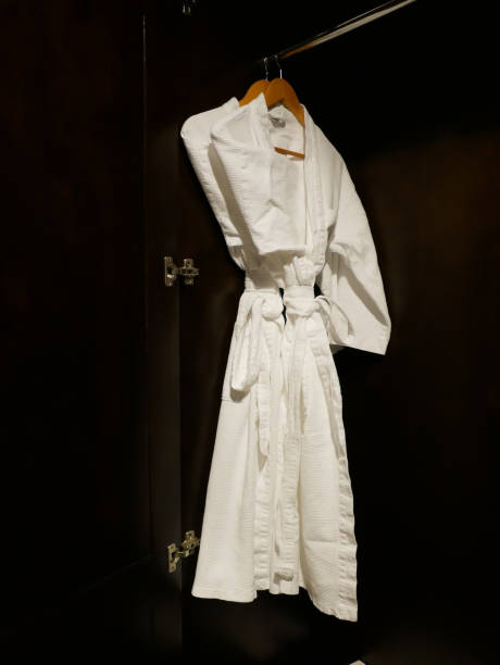 istock 2 White bathing gowns hang in wooden wardrobe 1223756203