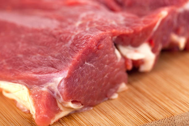 istock Raw meat on wooden board, fresh food 1223757255