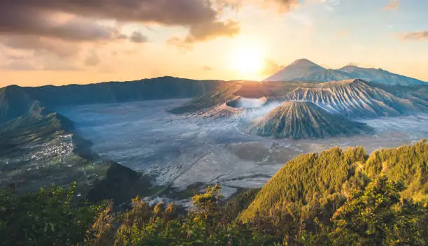 Early morning view of the Bromo caldeira in East Java in Indonesia. The volcanic formation of a few volcanoes, with the famous volcano Bromo and the Semeru volcano in the background attract everyday large crowds of visitors on the mountain top for sunrise. nature landscape background