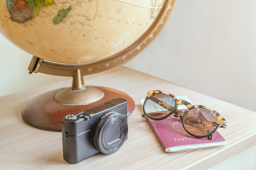 Concept travel, globe, photo camera,sunglasses,ticket airplane and passport on a wooden table. Idea, photo tourism, adventure, travel around the world