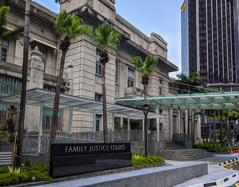 May 2020. Singapore. Main entrance with glass cover for cars and people coming into the The Family Justice Courts (FJC) are established pursuant to the Family Justice Act it sits in a main street near the Manpower Minister in Singapore in a building with old columns resembling a mausoleum. The court deals with matter of civil cases in respect to families.