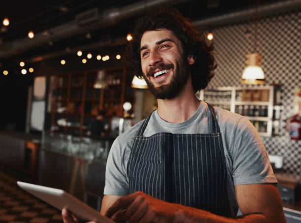 istock Handsome caucasian coffee shop owner laughing while holding digital tablet in hand 1223768583