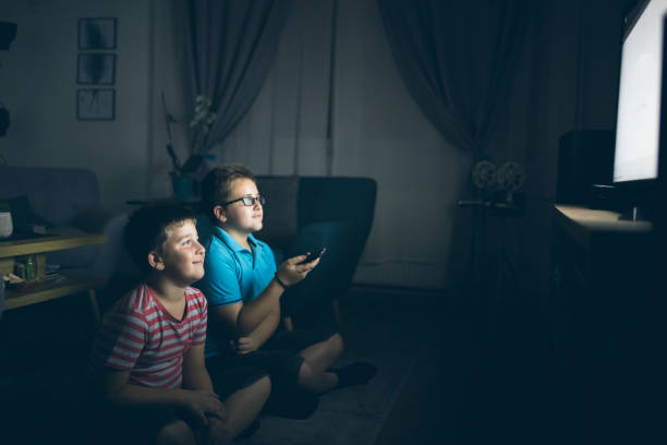 istock Boys watching a movie at home at night 1223771504