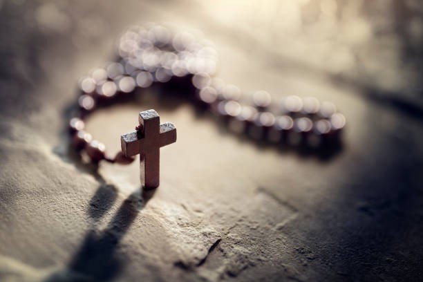 Close-up of hands holding a crucifix, symbolizing faith, devotion, and spirituality, with a dark, serene background.