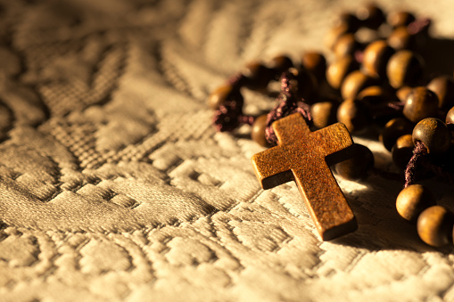 A wooden rosary with the cross on cloth