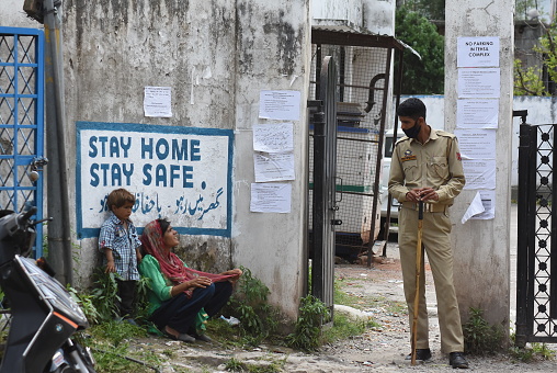A policeman talking to a begger woman near an administrative quarantine in Mendhar area of Poonch district on Saturday May 9, 2020