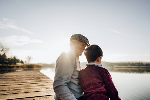 istock Grandfather and grandson sitting on a lake dock 1223788870