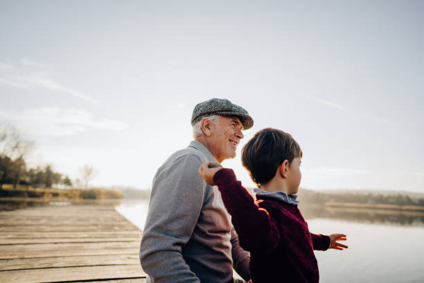 istock Grandfather and grandson sitting on a lake dock 1223788971