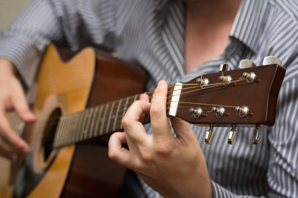 uomo sconosciuto che suona una chitarra acustica - plucking an instrument foto e immagini stock